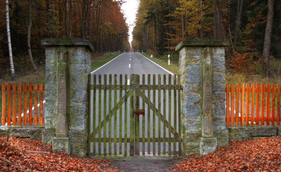 image of fence with lock and road ahead